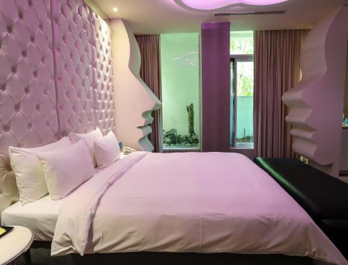 a bedroom with a large bed with a purple headboard at All-Ur Boutique Motel-Yi-Lan Branch in Yilan City
