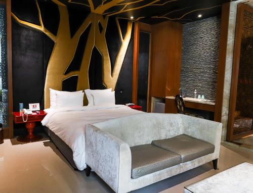 a bedroom with a bed with a tree wall at All-Ur Boutique Motel-Yi-Lan Branch in Yilan City
