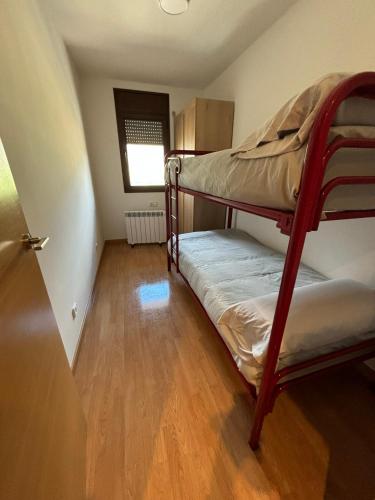 a bunk bed in a room with a wooden floor at Apartament l'Empalme d'Àger in Ager