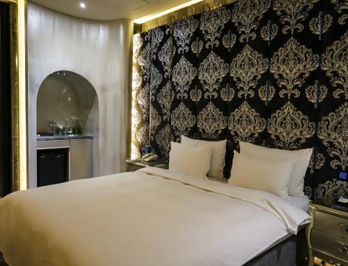 a bedroom with a bed and a black and gold wall at All-Ur Boutique Motel-Yi-Lan Branch in Yilan City