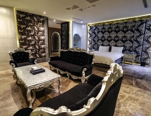 a hotel room with a bed and a couch and chairs at All-Ur Boutique Motel-Yi-Lan Branch in Yilan City