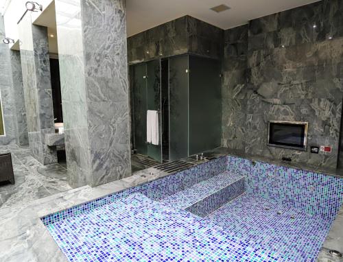 a bathroom with a large tub with blue tiles at All-Ur Boutique Motel-Yi-Lan Branch in Yilan City