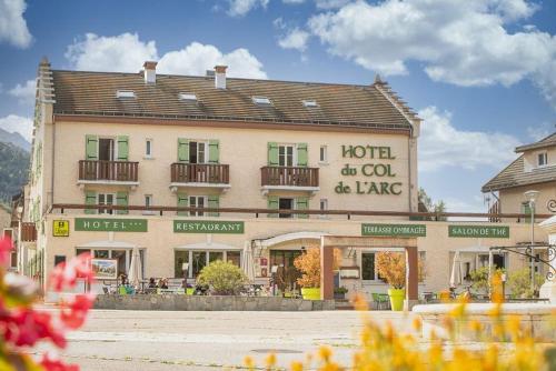 a large building with a hotel and a sign on it at Hotel du Col de l'Arc in Lans-en-Vercors