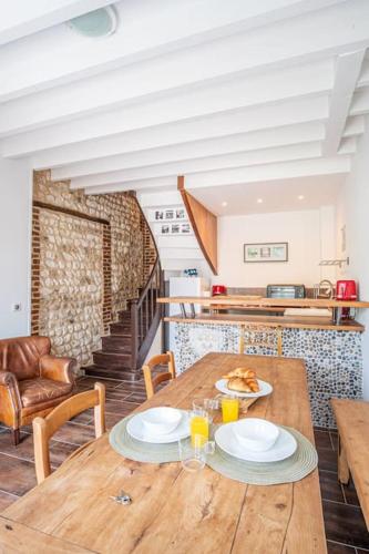 - une cuisine avec une table en bois et 2 assiettes dans l'établissement La Bicoque - Maison de pêcheur - Cour ext, à Étretat