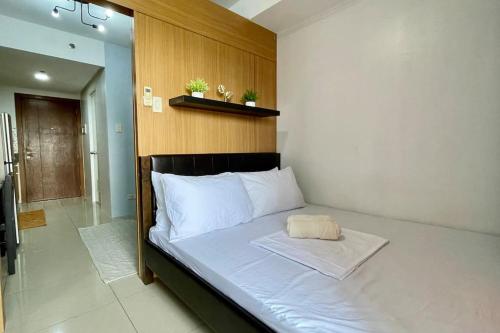 a bed with a wooden headboard in a room at Condo Suite Near NAIA 3 and Mall of Asia in Manila