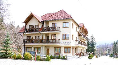 a large building with balconies on it in the snow at Pod Bukami - Chill&SPA in Szklarska Poręba