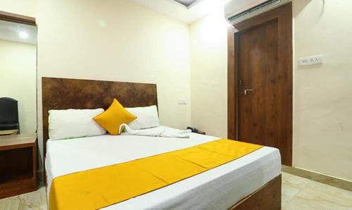 a bedroom with a large bed with yellow and white pillows at FabHotel Rama Inn I in Gwalior