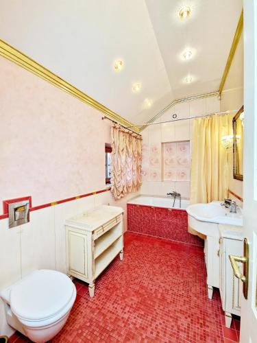 a bathroom with a toilet and a sink and a tub at Villa Eternity in Jūrmala