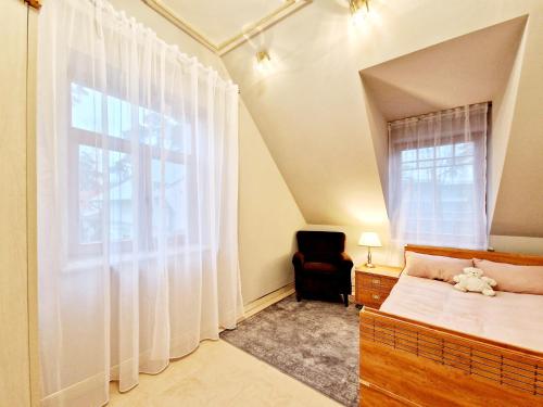Un dormitorio con una cama y una silla y una ventana. en Villa Eternity, en Jūrmala