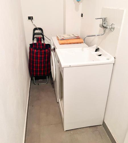 a suitcase is sitting next to a sink in a bathroom at Cavour 3 - Monolocale luminoso a due passi dalla Torre in Pisa