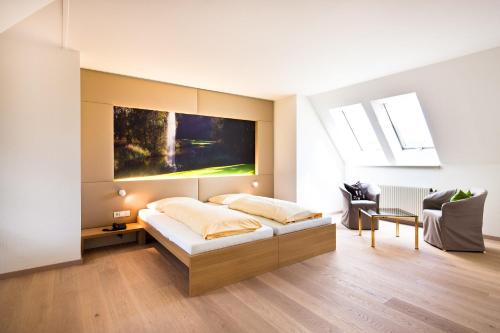 ein Schlafzimmer mit einem Bett und einem großen Wandgemälde in der Unterkunft Golfhotel Bodensee in Weißensberg