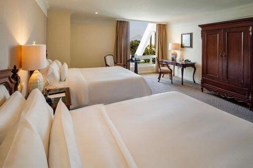 a hotel room with two beds and a desk at The Westin Camino Real, Guatemala in Guatemala