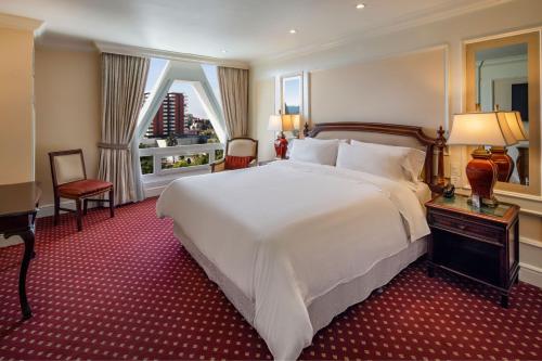 a bedroom with a large white bed and a window at The Westin Camino Real, Guatemala in Guatemala