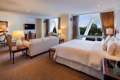 um quarto de hotel com uma cama grande e uma janela grande em The Westin Camino Real, Guatemala em Guatemala