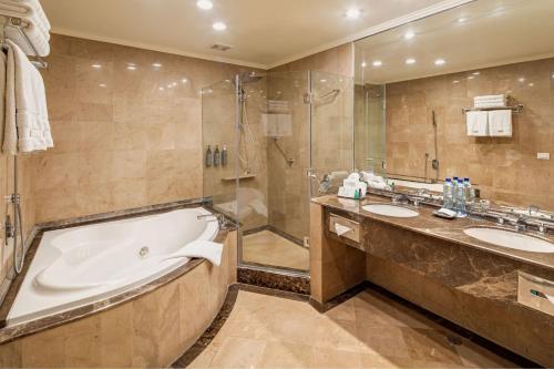 a bathroom with two sinks and a tub and a shower at The Westin Camino Real, Guatemala in Guatemala