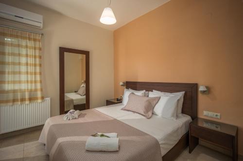 a hotel room with two beds and a mirror at Your Memories Hotel in Gouves