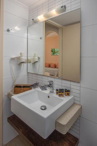 a white bathroom with a sink and a mirror at Your Memories Hotel in Gouves