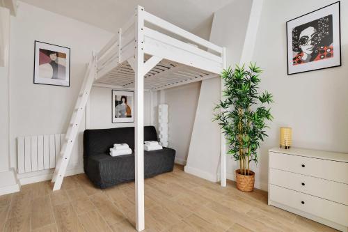 1 dormitorio con cama elevada y sofá en Cosy home with terrace near Canal Saint-Martin en París