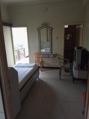 ein Schlafzimmer mit einem Bett und einem TV. in der Unterkunft NEW GREEN MOUNTAIN RESIDENCY in Udagamandalam