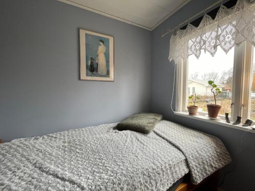 1 dormitorio con 1 cama y una foto en la pared en Stuga centrala Färjestaden med gångavstånd till det mesta, en Färjestaden