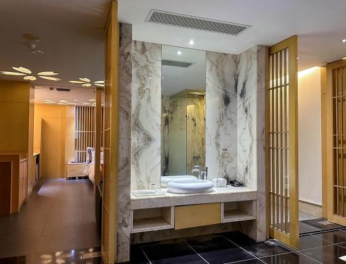 baño con lavabo y espejo grande en All-Ur Boutique Motel-Ping Tung Branch en Pingtung City