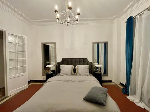 - une chambre avec un grand lit et un lustre dans l'établissement Blue horizon Prenium, à Marseille