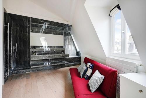 een woonkamer met een rode bank en een spiegel bij Modern Loft 2BDR Place des Ternes in Parijs