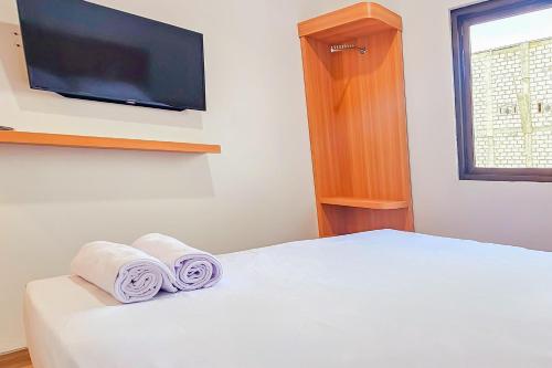 a bedroom with a bed with two rolled towels at Hotel Buana Express RedPartner in Bojonegoro