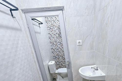 e bagno con doccia, servizi igienici e lavandino. di Hotel Buana Express Mitra RedDoorz a Bojonegoro