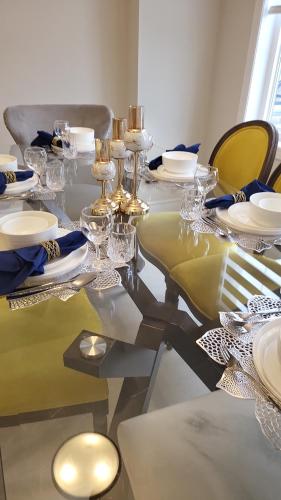 a dining table with plates and glasses on it at Luxury corner house in Milton