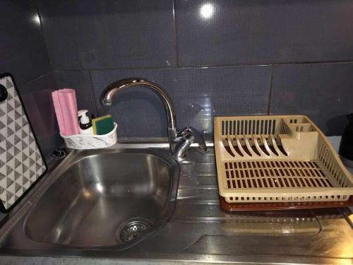 a kitchen sink with a strainer on top of it at COSY Living Apartment 1 in Kos Town