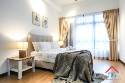 a bedroom with a bed and a table and a window at Astoria Ampang By Grabstay in Kuala Lumpur