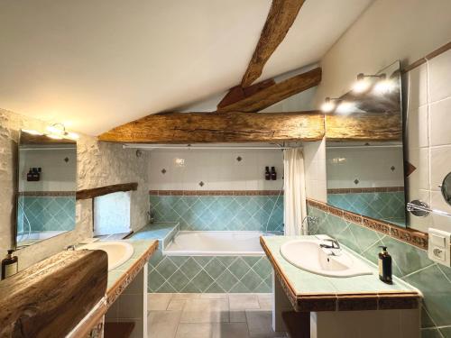 a bathroom with two sinks and a bath tub at Le Relais de Saint-Preuil, The Originals Relais (Relais du Silence) in Saint-Preuil