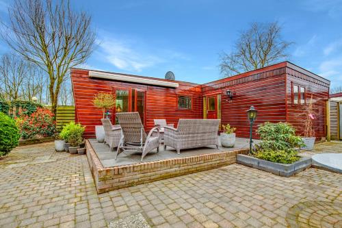 a wooden house with chairs and a table on a patio at Chalet Louis met riante tuin en 3 slaapkamer 6p in Putten