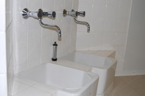 a bathroom with a sink and two faucets at Hotel Friesengeist in Wiesmoor