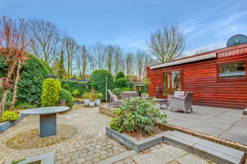 a patio with a red building and a table at Chalet Louis met riante tuin en 3 slaapkamer 6p in Putten
