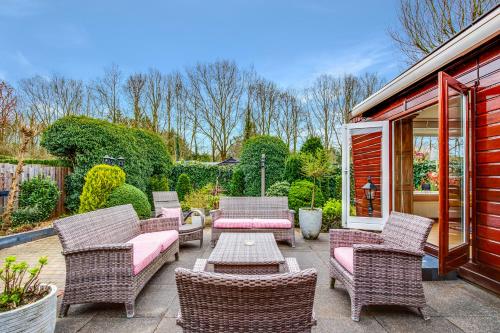 a patio with wicker chairs and a table at Chalet Louis met riante tuin en 3 slaapkamer 6p in Putten