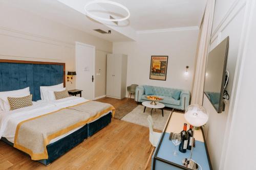 una camera d'albergo con un letto grande e un divano di Artist hotel a Subotica