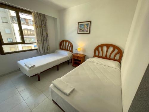 Cette chambre comprend 2 lits et une fenêtre. dans l'établissement Apartamentos Benicassim 3000, à Benicàssim