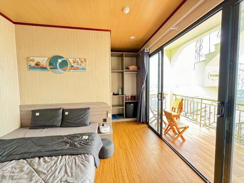um quarto com uma cama e uma varanda em Villa Phố Biển view biển Phú Quý em Cu Lao Thu