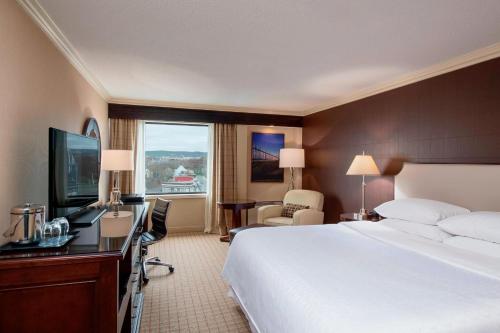 a hotel room with a bed and a desk and a television at Sheraton Hotel Newfoundland in St. John's