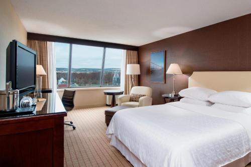 a hotel room with a large bed and a large window at Sheraton Hotel Newfoundland in St. John's