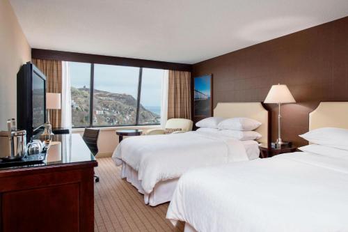 a hotel room with two beds and a large window at Sheraton Hotel Newfoundland in St. John's
