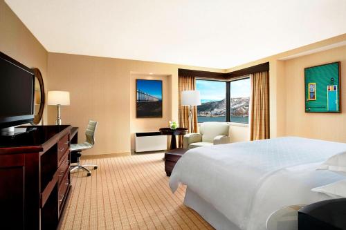 a hotel room with a bed and a desk and a television at Sheraton Hotel Newfoundland in St. John's