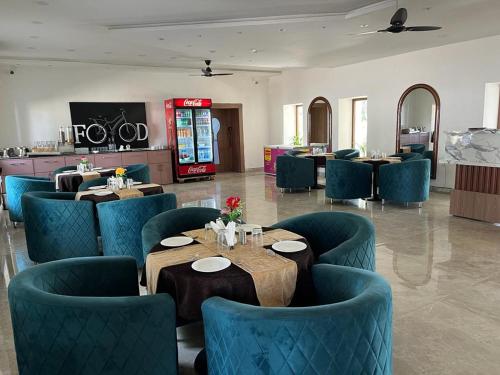 Rewa的住宿－Hotel Eco Park Rewa，一间在房间内配有蓝色椅子和桌子的餐厅
