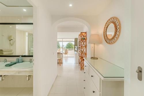 a white bathroom with a sink and a mirror at Secret View Riviera Miraflores in La Cala de Mijas