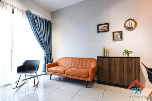 a living room with a leather couch and a cabinet at Astoria Ampang By Grabstay in Kuala Lumpur