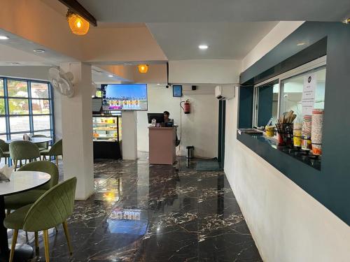 Un restaurante con un mostrador, mesas y sillas. en Hotel Eco Park By Bookingcare, en Rewa