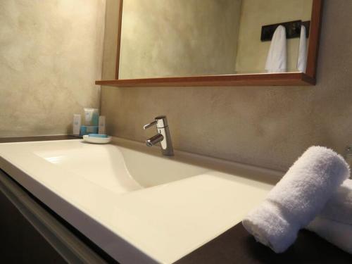 
a white sink sitting under a mirror in a bathroom at Villa Montaña Beach Resort in Isabela
