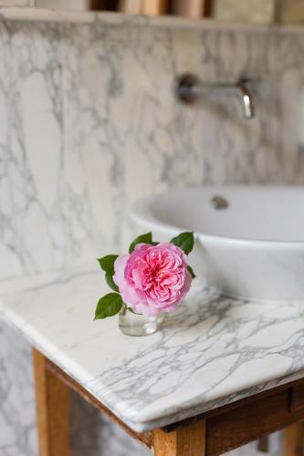 a pink rose in a vase on a bathroom counter at Villa Cri Cri B&B di Charme in San Benedetto del Tronto